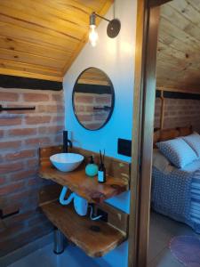 een badkamer met een wastafel en een bed in een kamer bij Chalé Sítio São José in Santo Antônio do Pinhal