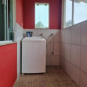 um pequeno frigorífico num quarto com paredes vermelhas em Casa no Sítio em Penha