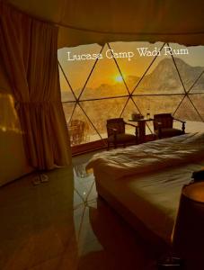 a hotel room with a bed and a table and chairs at Lukasa camp Wadi Rum in Wadi Rum