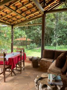 ein Wohnzimmer mit einem Sofa und einem Tisch in der Unterkunft Pousada Árvore Centenária in São Thomé das Letras