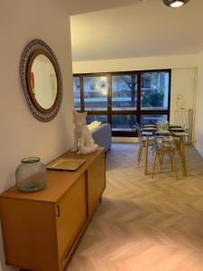 a living room with a table and a mirror at Magnifique Appartement, 3 min de Paris in Levallois-Perret