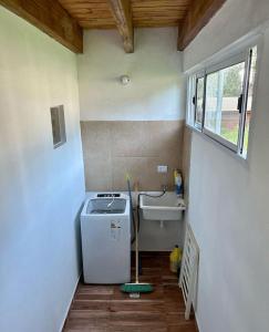 a small bathroom with a sink and a washing machine at Gobernador Roca Duplex in Gobernador Roca