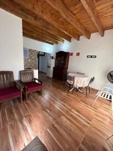 a living room with wooden floors and a table and chairs at Gobernador Roca Duplex in Gobernador Roca