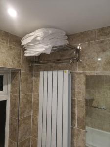 La salle de bains est pourvue d'une douche et d'une serviette blanche. dans l'établissement NightRest Homes 5 Bedroom House - Smart Tv in Each Room-Parking-Wifi, à Welwyn Garden City