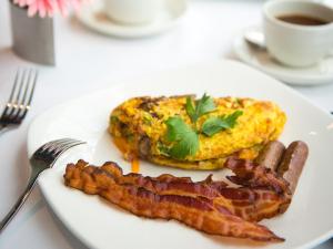 un piatto di cibo con pancetta e uova e una tazza di caffè di Grand Traverse Resort and Spa a Traverse City