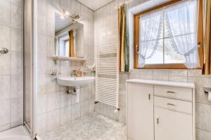 ein Badezimmer mit Waschbecken und Toilette und einem Fenster in der Unterkunft Haus Alvier by A-Appartments in Brand
