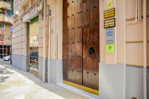 una grande porta di legno sul lato di un edificio di Alba e i Mori a Palermo