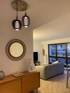 uma sala de estar com um sofá e um espelho em Magnifique Appartement, 3 min de Paris em Levallois-Perret