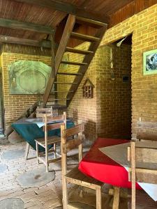 patio con mesa, sillas y pared de ladrillo en Pousada Árvore Centenária en São Thomé das Letras