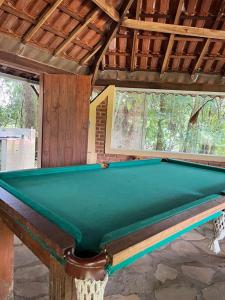 una mesa de billar verde en una habitación con en Pousada Árvore Centenária en São Thomé das Letras