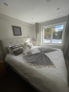 1 dormitorio con 1 cama blanca grande y ventana en Verbier Apt 2 rooms (3 guests), en Verbier