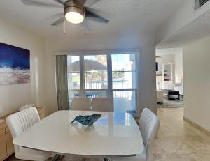 a dining room with a white table and chairs at Madeira Beach Yacht Club 247f in St. Pete Beach