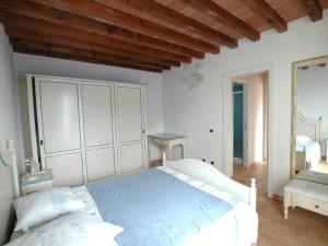 um quarto com uma cama branca e um tecto de madeira em Villaggio Di Mezzo Ortano em Rio Marina