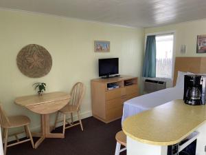 a room with a bed and a table and a television at Moontide Motel, Apartments, and Cabins in Old Orchard Beach