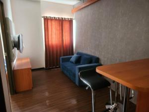 ein Wohnzimmer mit einem blauen Sofa und einem Tisch in der Unterkunft Metro Suits Apartment Bandung in Bandung