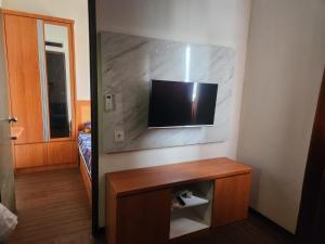Zimmer mit einem Flachbild-TV an der Wand in der Unterkunft Metro Suits Apartment Bandung in Bandung