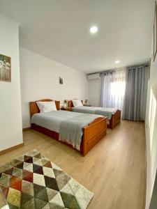 - une chambre avec 2 lits et un tapis dans l'établissement CASA do AÇÔR, à Aldeia das Dez