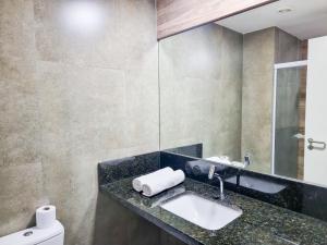 a bathroom with a sink and a mirror at Ilusion Flat Ponta Negra in Natal +1 photo