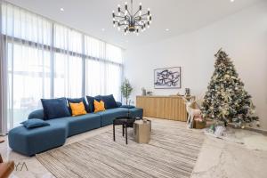 a living room with a blue couch and a christmas tree at AYA Boutique - Oasis in Al Muntazah 3BR Villa with Private Pool in Abu Dhabi