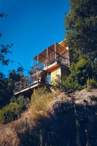 a building on top of a hill with trees at LES CABANES DE LUTINA 