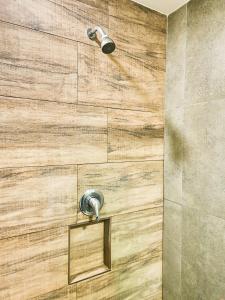 a shower with a wooden wall in a bathroom at Ilusion Flat Ponta Negra in Natal
