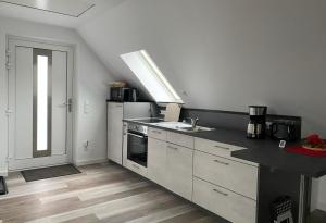 a kitchen with a sink and a stove top oven at Ferienhaus Helfert FeWo2 mit eigener Terrasse in Senftenberg