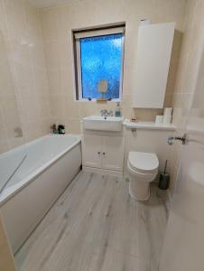 a bathroom with a tub and a toilet and a sink at Single room with Castle view in leafy Edinburgh South in Edinburgh