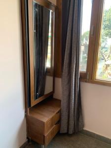 a wooden dresser in a room with a window at Modern Comforts with a view in Dehradun