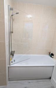 a white bath tub in a bathroom with a shower at Single room with Castle view in Edinburgh