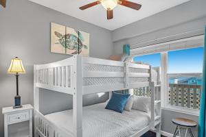 a white bedroom with a bunk bed and a window at Baywatch Unit H5 in Pensacola Beach +30 photos