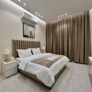 a bedroom with a large bed and a large window at منتجعات رغيد الفندقية in Hail