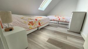 um quarto com 2 camas e uma mesa de cabeceira com um candeeiro em Ferienhaus Helfert FeWo2 em Niemtsch