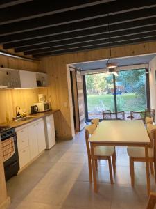 a kitchen and dining room with a table and chairs at Galpon de Burgos - SalePatagonia in San Martín de los Andes