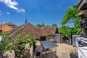 a patio with a wooden chair and a house at MONA NEST Canggu 2BR Tiny House with Rooftop and Cozy Workspace in Dalung