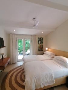 1 dormitorio con 2 camas blancas y ventana en Cape Standard Guest House, en Ciudad del Cabo