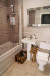 La salle de bains est pourvue de toilettes, d'un lavabo et d'une baignoire. dans l'établissement Luxury 4Bed Townhouse - Parking+Wi-Fi+Amenities, à Nuneaton