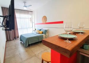 um quarto com uma cama e uma mesa com copos de vinho em Studio reformado e Internet rápida praça Roosevelt em São Paulo