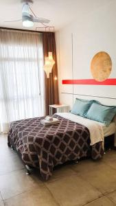 um quarto com uma cama e uma parede vermelha e branca em Studio reformado e Internet rápida praça Roosevelt em São Paulo