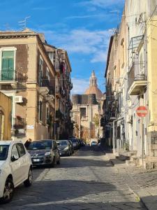 eine Stadtstraße mit auf der Straße geparkt in der Unterkunft Gesuiti Home di Agata e Aurora in Catania