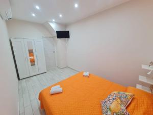 ein Schlafzimmer mit einem orangenen Bett mit Handtüchern darauf in der Unterkunft Gesuiti Home di Agata e Aurora in Catania