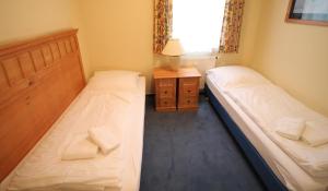 Duas camas num pequeno quarto com uma janela em Apartment zum See em Ascheberg