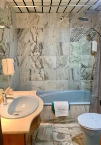 a bathroom with a sink and a tub at Hotel Puma in Maia