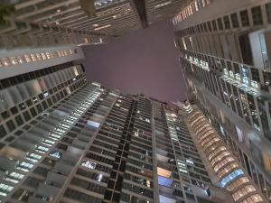 Blick auf zwei hohe Gebäude in der Nacht in der Unterkunft Regalia Comfort Suites KLCC SkyPool in Kuala Lumpur