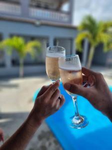 2 personnes retiennent des verres de champagne dans l'établissement Espaço Sol e Mar - Praia Azul/PB, à Pitimbu