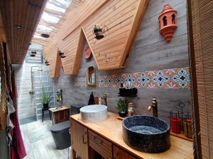 a bathroom with a sink and a wooden wall at La Vista, chambre chez l'habitant in Trois-Rivières