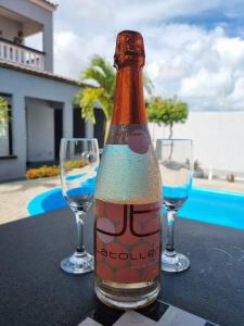 eine Flasche Bier auf einem Tisch mit zwei Weingläsern in der Unterkunft Espaço Sol e Mar - Praia Azul/PB in Pitimbu