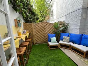a small patio with chairs and blue pillows at Cambray Apartment in Cheltenham