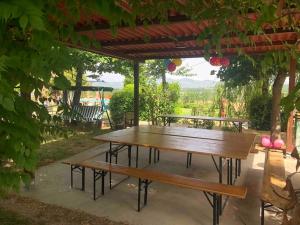 a wooden picnic table under a pergola at "Villa Bizzi" in Monte Castelli