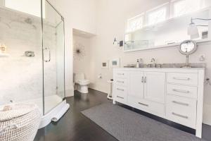 baño blanco con ducha y lavamanos en Pacific Heights Victorian Garden Suite en San Francisco