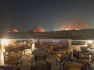 开罗Yamour Pyramids View的晚上,餐厅设有桌椅